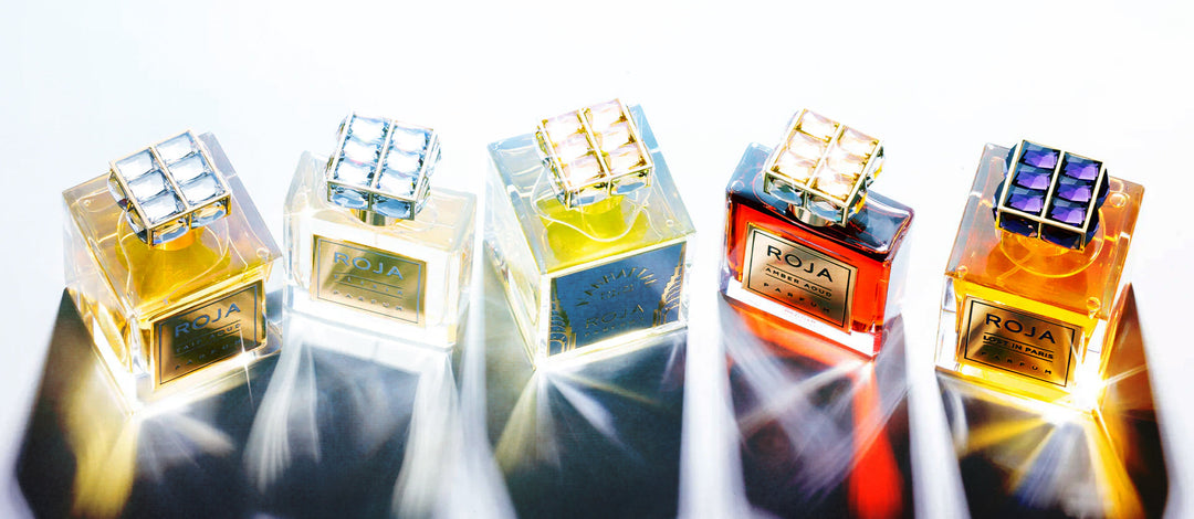 Roja Parfums perfume bottles shown from overhead with each cap a different colour twinkling in the light.